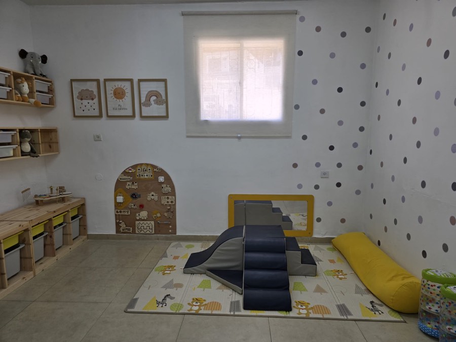 חדר משחק עם מגלשה רכה ולוח פעילות